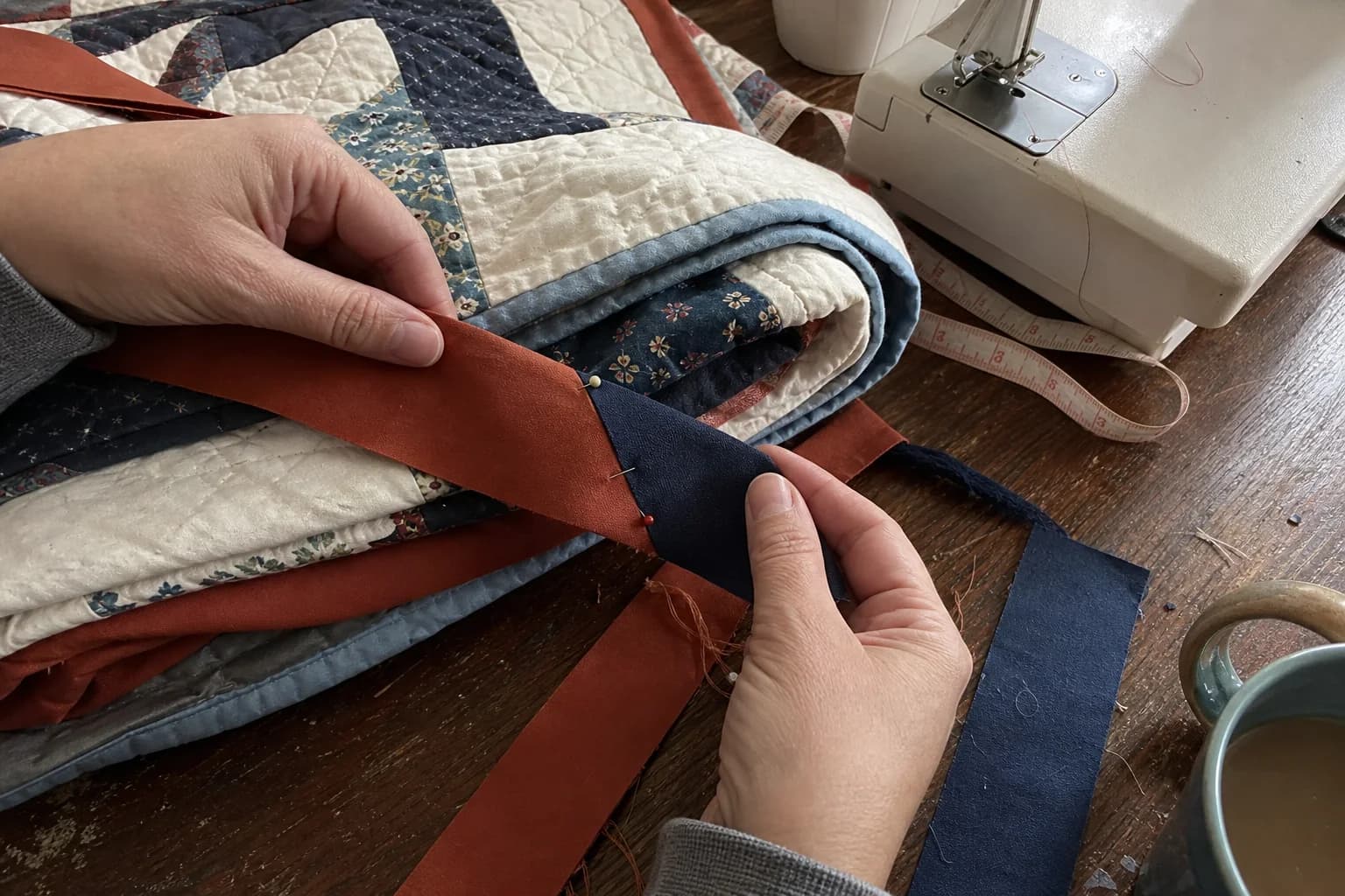 Freshly cut binding strips, a small ruler, clips, and pencil notes on a sewing table.